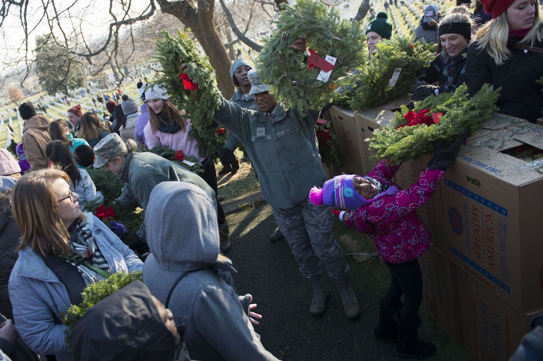 Airmen pass out wreaths to volunteers.