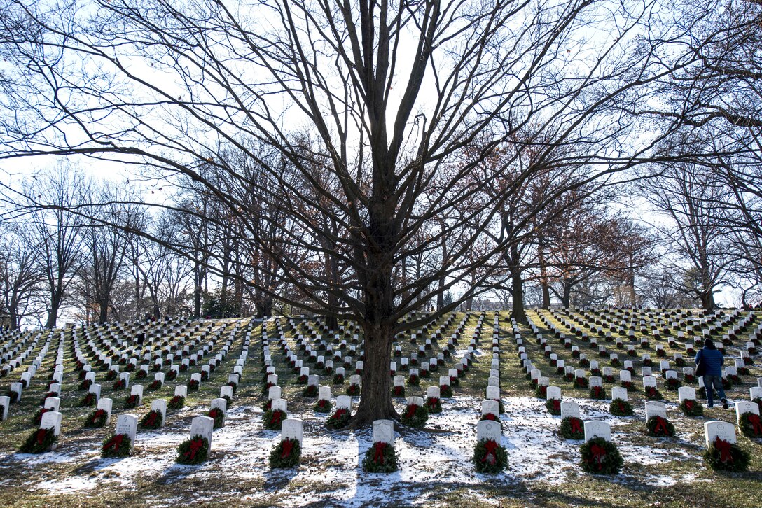 Wreaths lay at headstones in rows.