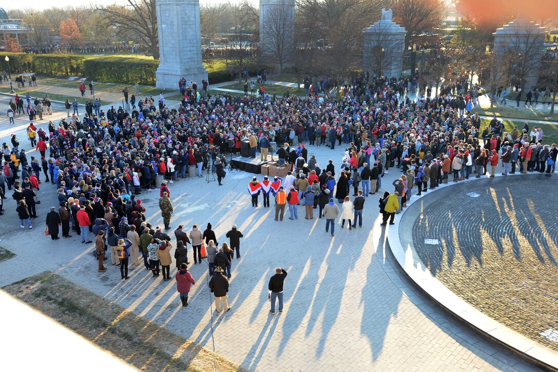 As seen from above, people gather around a person speaking.