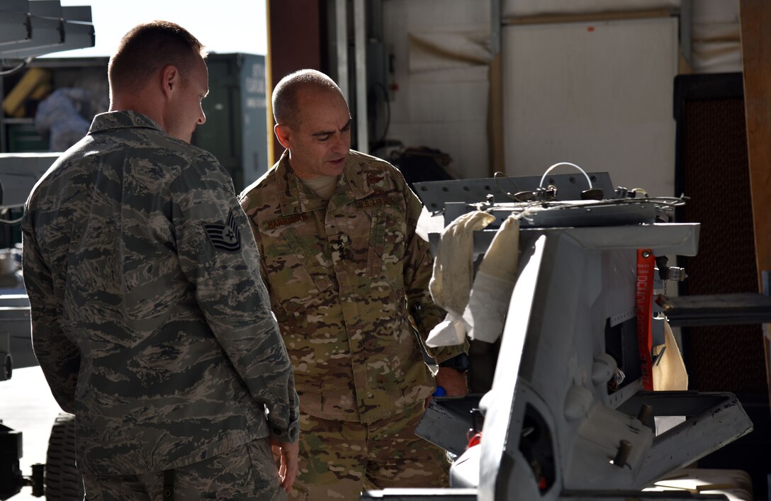 U.S. Air Force Lt. Gen. Jeffery Harrigian, U.S. Air Forces Central Command Commander, talks with Tech. Sgt. Philip Smith, 100th Expeditionary Fighter Squadron Armament Maintenance
Section NCO in charge, at the 407th Air Expeditionary Group in Southwest Asia, Dec. 14, 2017. Smith talked about a new electrical component for the pylon integrated dispenser system universal. (U.S. Air Force photo by Staff Sgt. Joshua Edwards/Released)