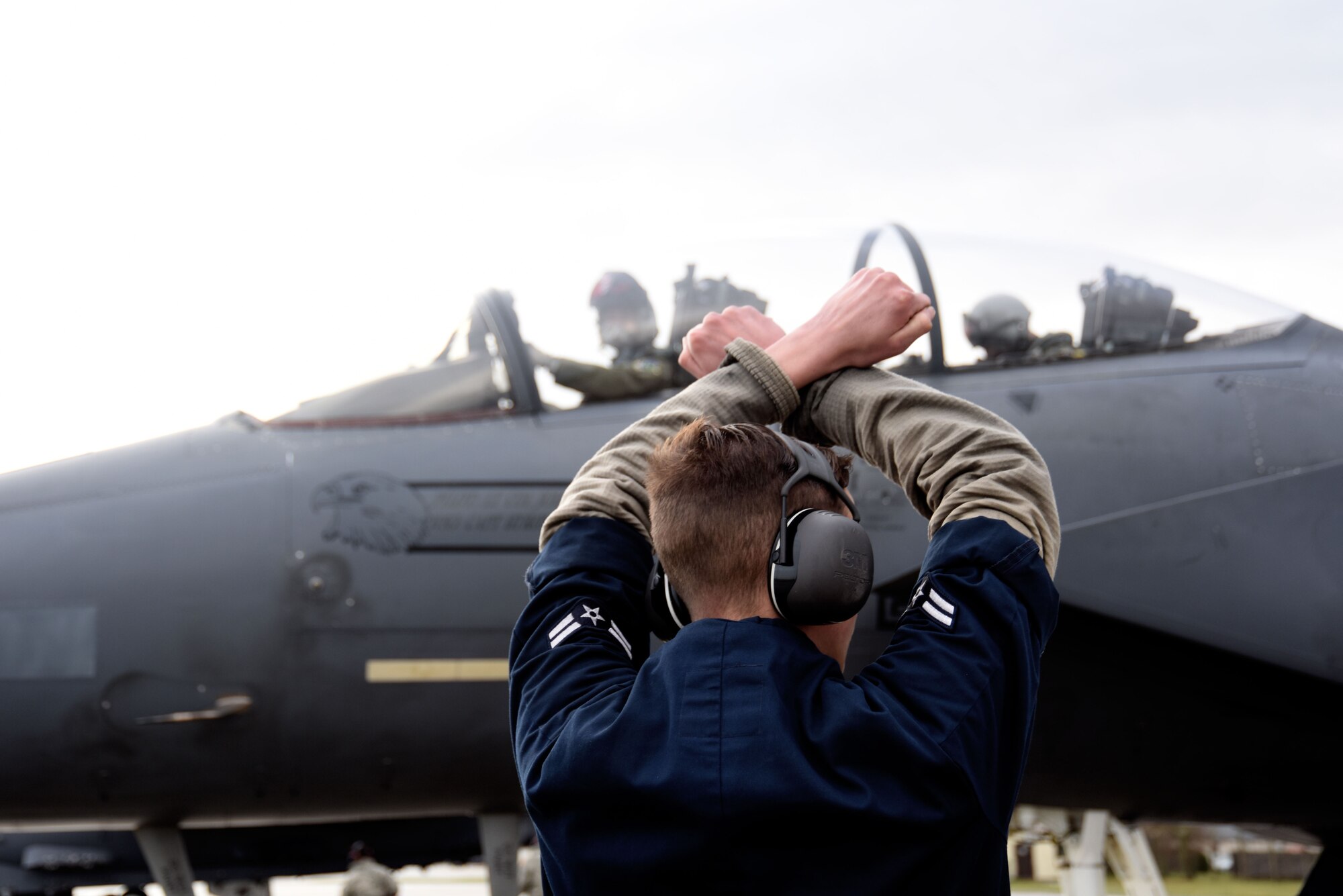 A 48th Aircraft Maintenance Squadron crew chief marshals an F-15E Strike Eagle as it taxis in for its end-of-runway inspection after landing at Royal Air Force Lakenheath, England, Dec. 13. Any issues discovered during the inspection are reported to the relevant aircraft maintenance unit. (U.S. Air Force photo/Senior Airman Abby L. Finkel)