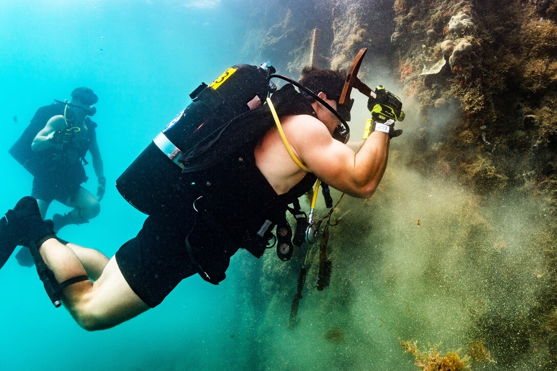 A Navy diver conducts an underwater pier survey.
