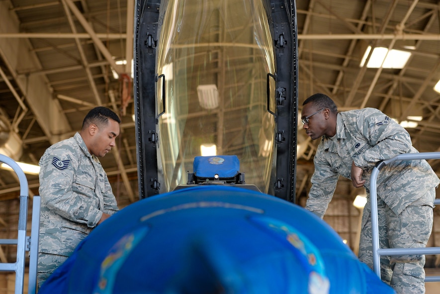 Tech. Sgt. Joel Alfaro-Salazar, 944th Fighter Wing aircrew egress systems technician, and Airman 1st Class Diamond Balock-White, 56th Component Maintenance Squadron egress systems technician, prepare to lift a seat from an F-16 Fighting Falcon using a new raise pin assembly at Luke Air Force Base, Ariz., Dec. 8, 2017. The raise pin assembly was tested against the current legacy raise bar method used to suspend the ejection seat in the maintenance position. (U.S. Air Force photo/Airman 1st Class Caleb Worpel)