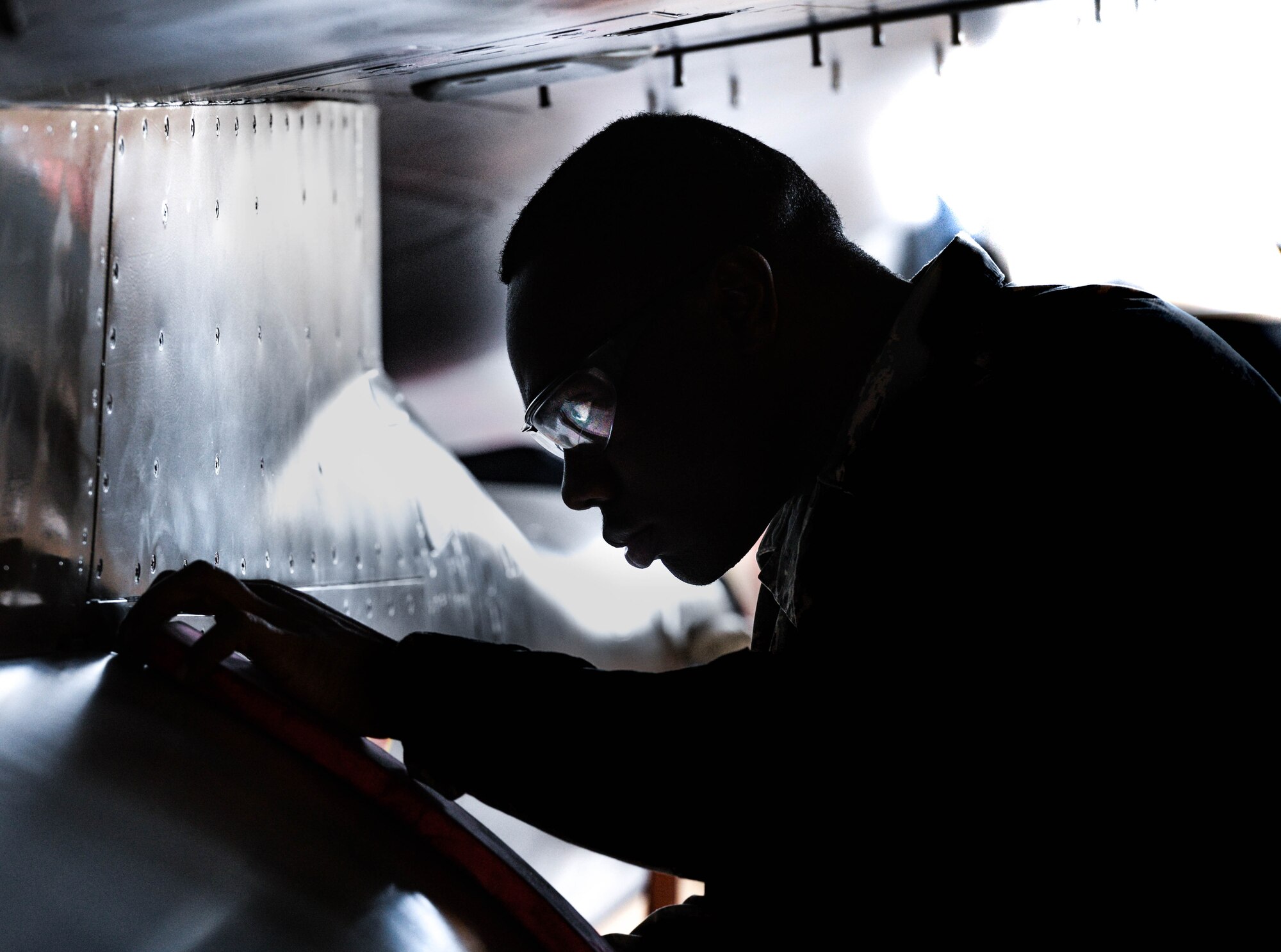Airman 1st Class Diamond Balock-White, 56th Component Maintenance Squadron egress systems technician, inspects an F-16 Fighting Falcon at Luke Air Force Base, Ariz., Dec. 8, 2017. Balock-White performed a demonstration on the benefits of using a new raise pin assembly to suspend the ejection seat in the maintenance position. (U.S. Air Force photo/Airman 1st Class Caleb Worpel)