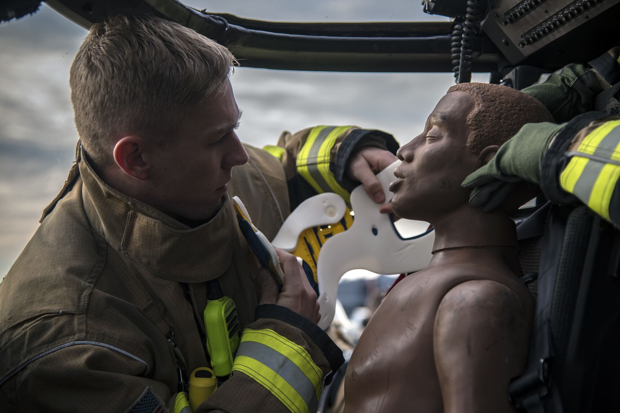 Airman 1st Class Austin Taylor, 23d Civil Engineer Squadron (CES) firefighter, applies a neck brace to a mannequin, Dec. 15, 2017, at Moody Air Force Base, Ga. Members from the 723d Aircraft Maintenance Squadron (AMXS) and 23d Civil Engineer Squadron (CES) participated in a training day to help improve their readiness and get extra practice at their crafts. The AMXS performed maintenance on helicopters and the CES conducted rescue operations by extinguishing a mock fire within an HH-60G Pave Hawk and extracting injured victims. (U.S. Air Force photo by Airman Eugene Oliver)
