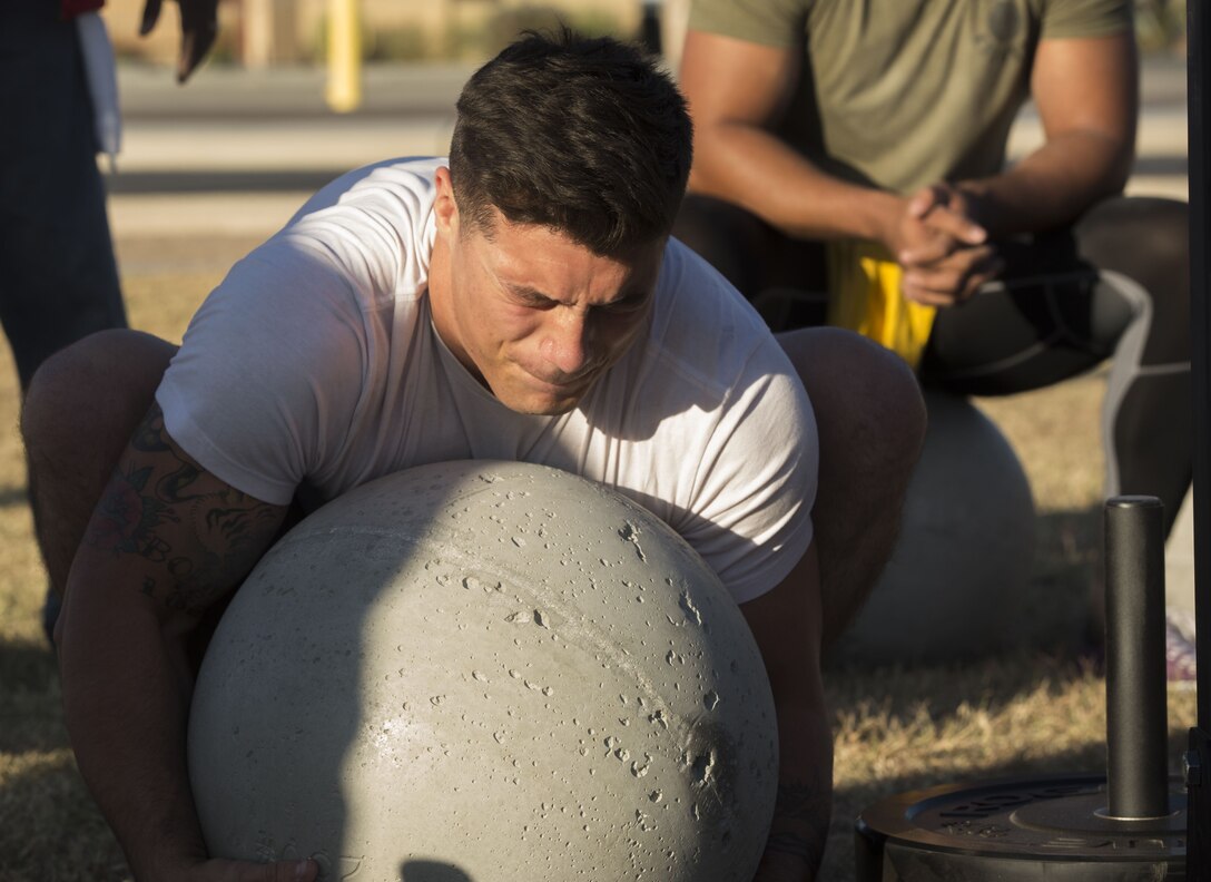 U.S. Marine Corps Cpl. Noah Diaz, an Aviation Ordnance Technician assigned to Marine Aviation Logistics Squadron 13, stationed at Marine Corps Air Station (MCAS) Yuma, Ariz., lifts an Atlas Stone to practice for the Strongman Competition Dec. 15, 2017 on the station parade deck. Atlas Stones are large balls of concrete used to test strength. The practice is to prepare for the Bull of the Desert Strongman Competition slated Feb. 17, 2018 in Yuma, Ariz. (U.S. Marine Corps photo by Lance Cpl. Sabrina Candiaflores)