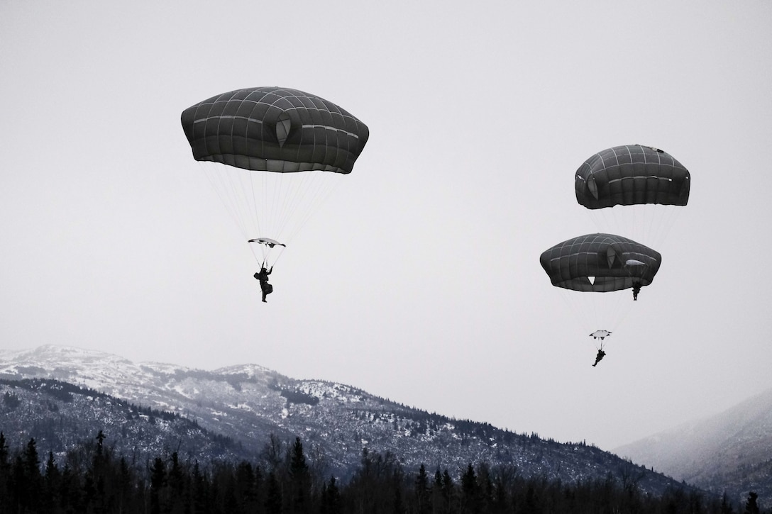 Paratroopers land during parachute training.