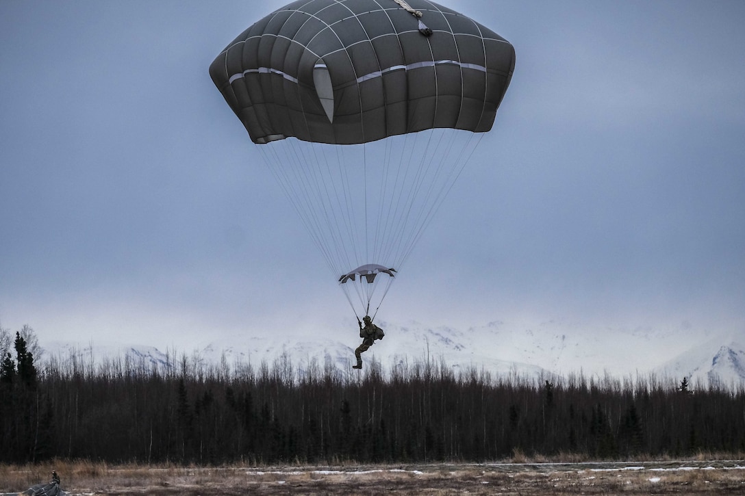 A paratrooper lands after parachute training.