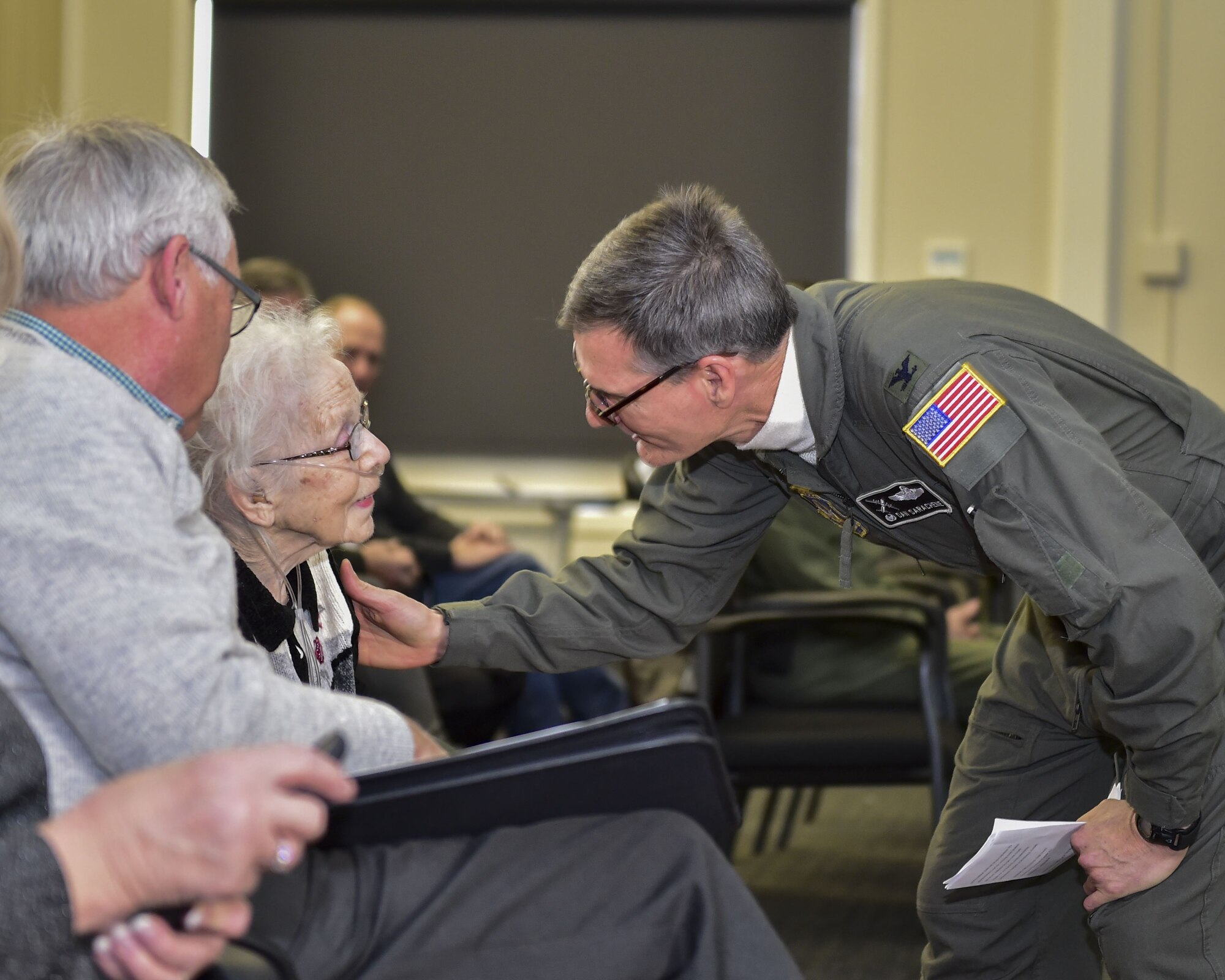 Col. Dan Sarachene (center), 910th Airlift Wing commander, greets Mary "Laverne" Kubli, widow of Fred Kubli Jr., during a building dedication ceremony here, Dec. 15, 2017.