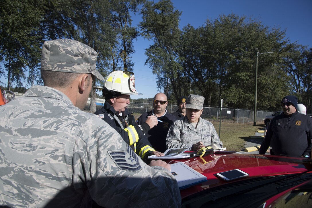 Members from Moody Air Force Base and local emergency responders discuss courses of action during an exercise scenario, Dec. 13, 2017, in Valdosta, Ga. Fire departments from Lowndes County, Valdosta, Tifton and Albany, the 23d Civil Engineer Squadron’s Fire Department and Emergency Management Flights, and 23d Medical Group Bioenvironmental Engineering Flight responded to the aftermath of a simulated tornado hitting the Du Pont Crop Protection factory. (U.S. Air Force photo by Staff Sgt. Eric Summers Jr.)