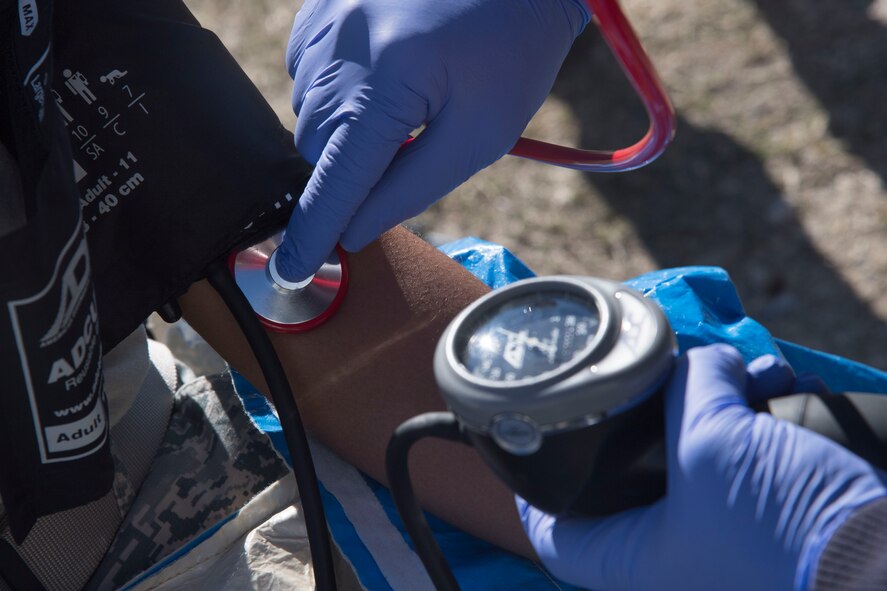 A Valdosta Fire Department paramedic takes the blood pressure of Airman 1st Class Briana Mciver, 23d Bioenvironmental Engineering Flight apprentice, before she dons chemical protective gear, Dec. 13, 2017, in Valdosta, Ga. Fire departments from Lowndes County, Valdosta, Tifton and Albany, the 23d Civil Engineer Squadron’s Fire Department and Emergency Management Flights, and 23d Medical Group Bioenvironmental Engineering Flight responded to the aftermath of a simulated tornado hitting the Du Pont Crop Protection factory. (U.S. Air Force photo by Staff Sgt. Eric Summers Jr.)