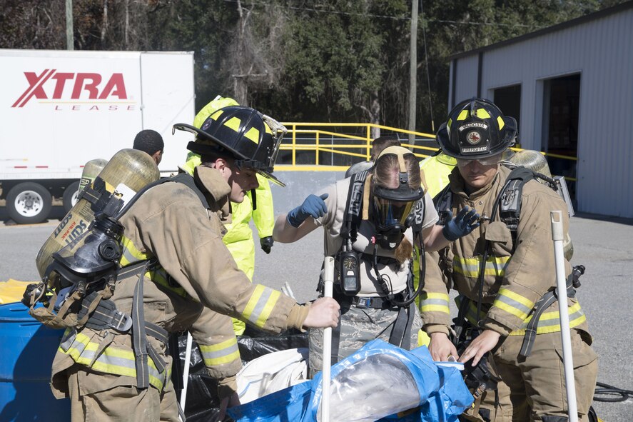 Two Valdosta Fire Department fire fighters help Staff Sgt. Breanna Faulkner, 23d Civil Engineer Squadron Emergency Management Flight craftsman, through the decontamination area, Dec. 13, 2017, in Valdosta, Ga. Fire departments from Lowndes County, Valdosta, Tifton and Albany, the 23d Civil Engineer Squadron’s Fire Department and Emergency Management Flights, and 23d Medical Group Bioenvironmental Engineering Flight responded to the aftermath of a simulated tornado hitting the Du Pont Crop Protection factory. (U.S. Air Force photo by Staff Sgt. Eric Summers Jr.)