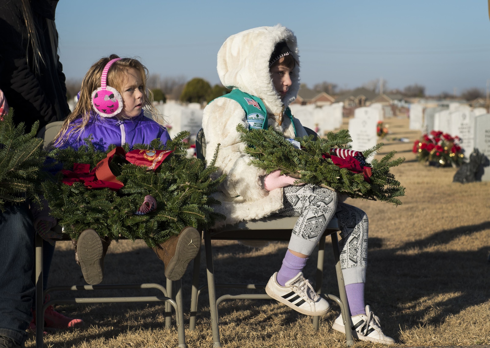 Volunteers from Girl Scout's Troop 283 wait to place wreaths during a Wreaths Across America ceremony at the Altus Cemetery, Okla., Dec. 16, 2017