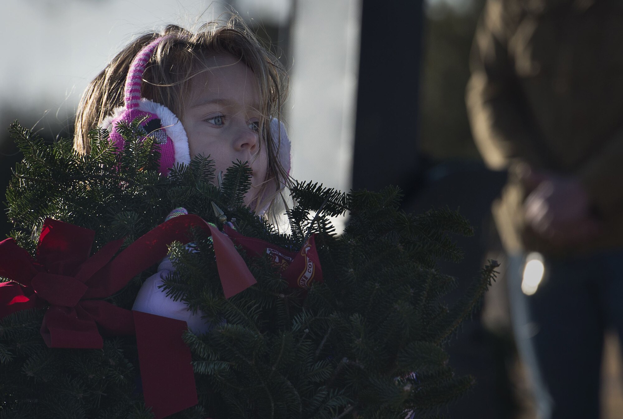 A volunteer from Girl Scout's Troop 283 places a wreath during a Wreaths Across America ceremony at the Altus Cemetery, Okla., Dec. 16, 2017.
