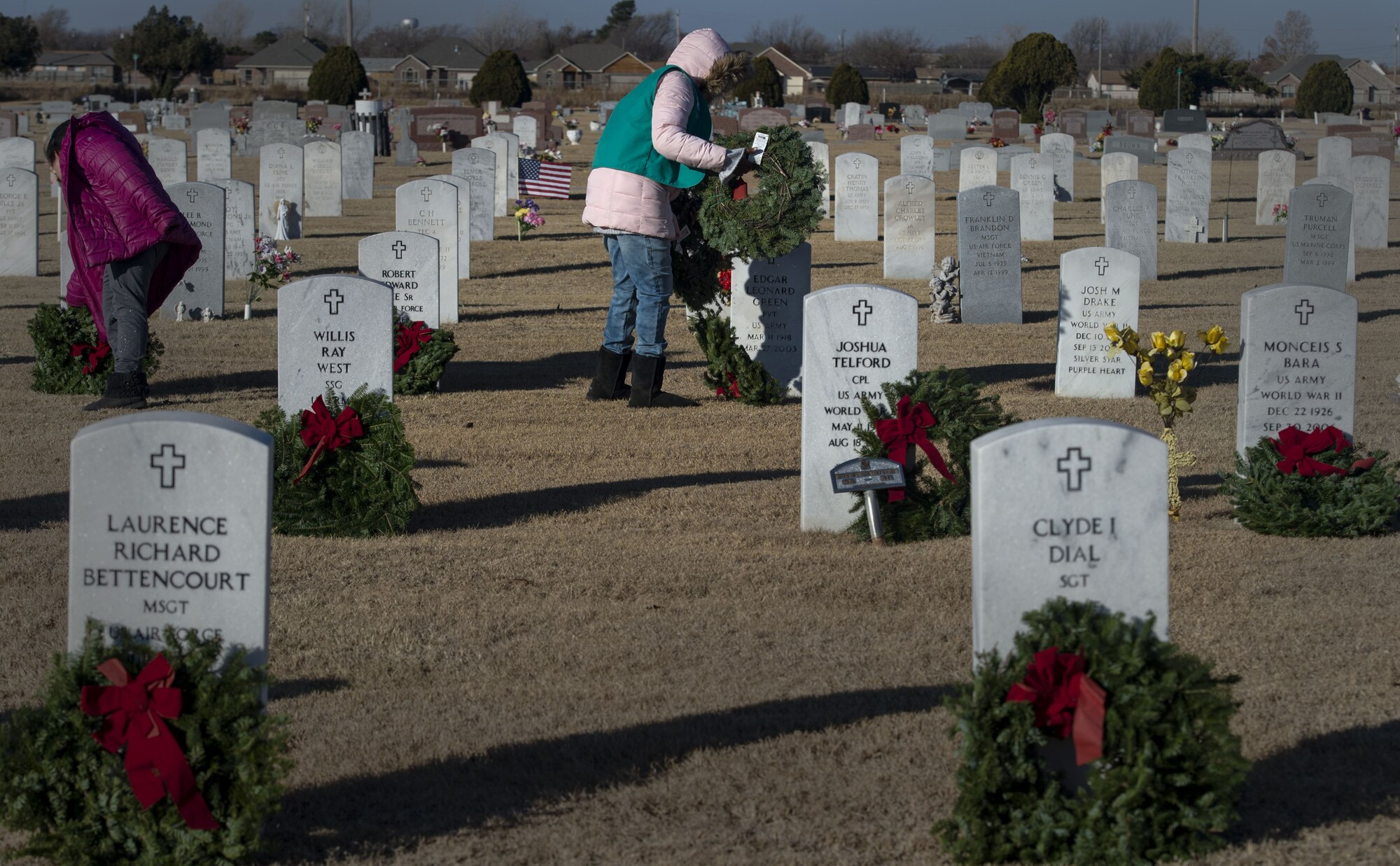 Volunteers from the local community place wreaths on veterans' graves during a Wreaths Across America ceremony at the Altus Cemetery, Okla., Dec. 16, 2017.