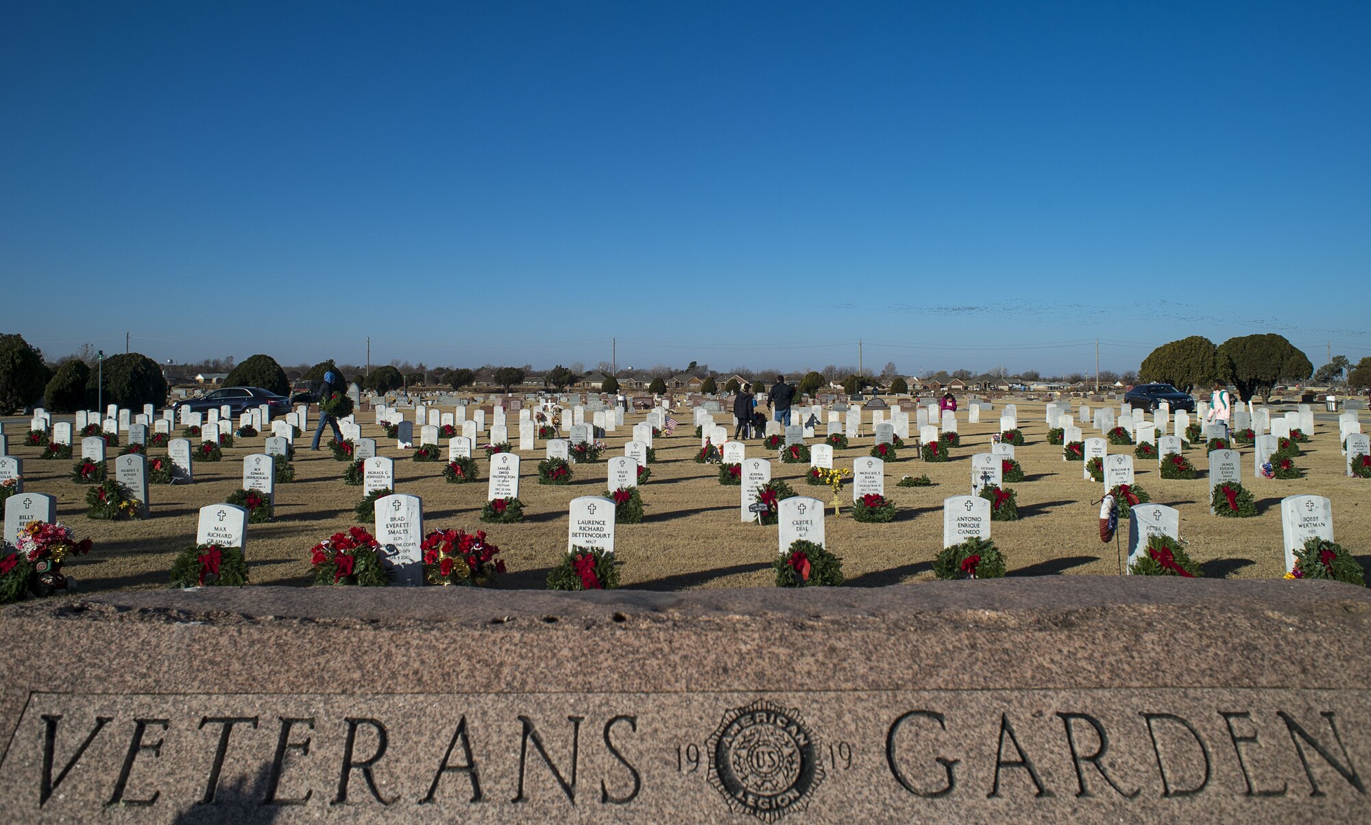 Volunteers from the local community place wreaths on veteran's graves during a Wreaths Across America ceremony at the Altus Cemetery, Okla., Dec. 16, 2017.