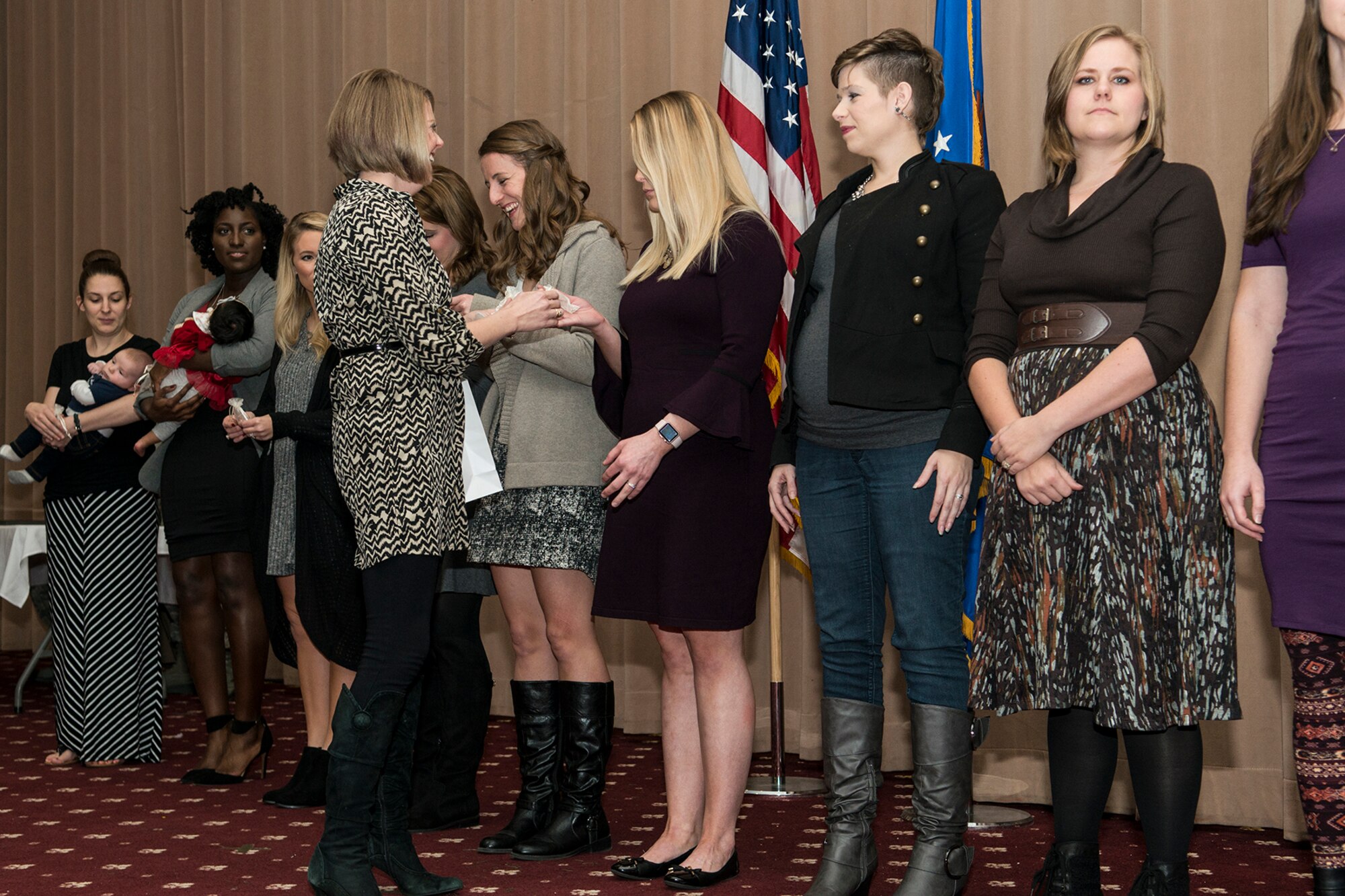 Jennifer Fish, the wife of Lt. Col. William Fish, 11th Bomb Squadron commander, presents a token to the spouses of the graduates of Formal Training Unit class 17-02 during the graduation ceremony on Barksdale Air Force Base, La. December 15, 2017.