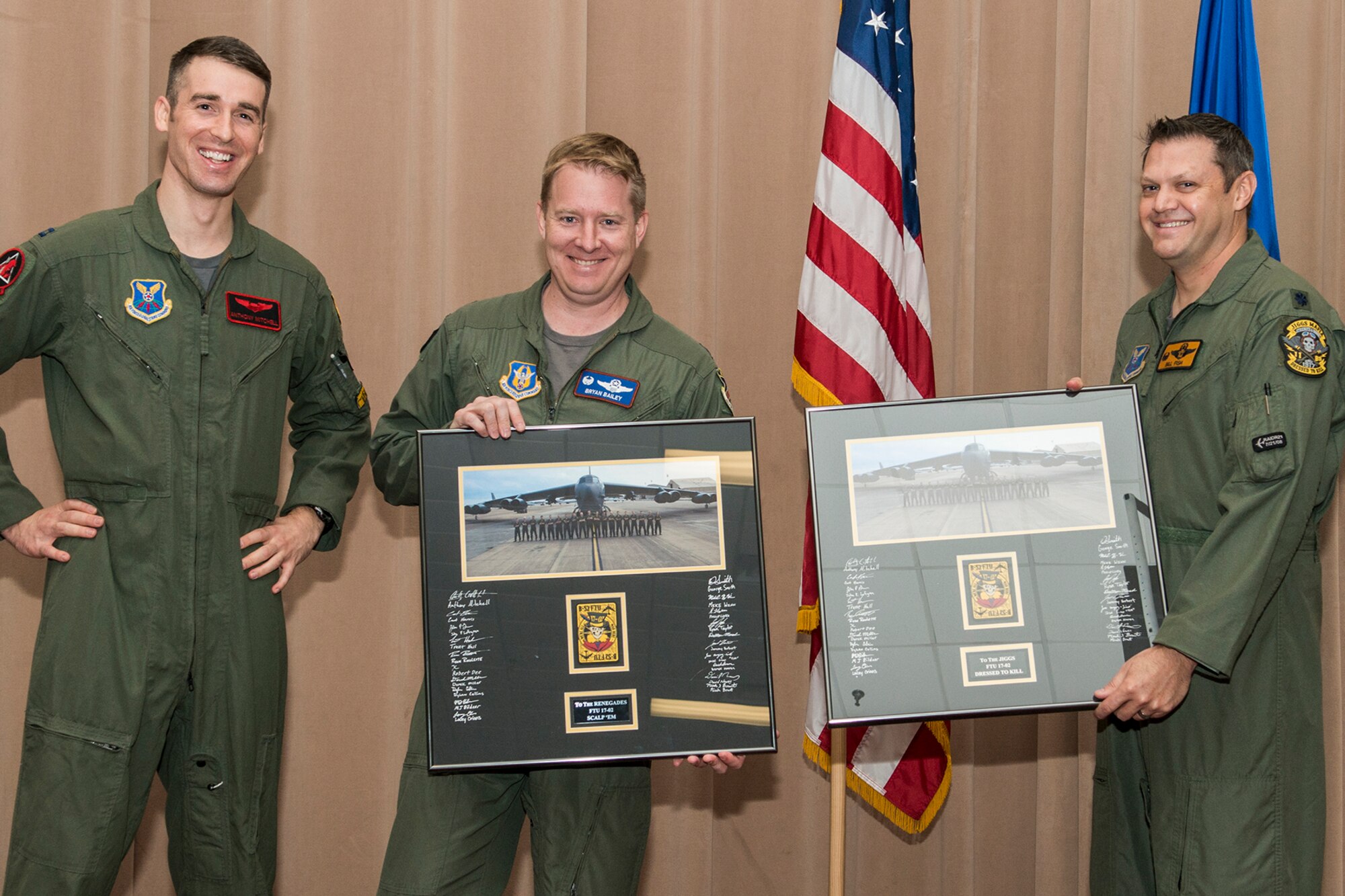 U.S. Air Force Capt. Anthony Mitchell presents class photos to Lt. Col. Brian Bailey, 93rd Bomb Squadron commander, and Lt. Col. William Fish, 11th BS commander, during a graduation ceremony for Formal Training Unit class 17-02 on Barksdale Air Force Base, La. December 15, 2017.