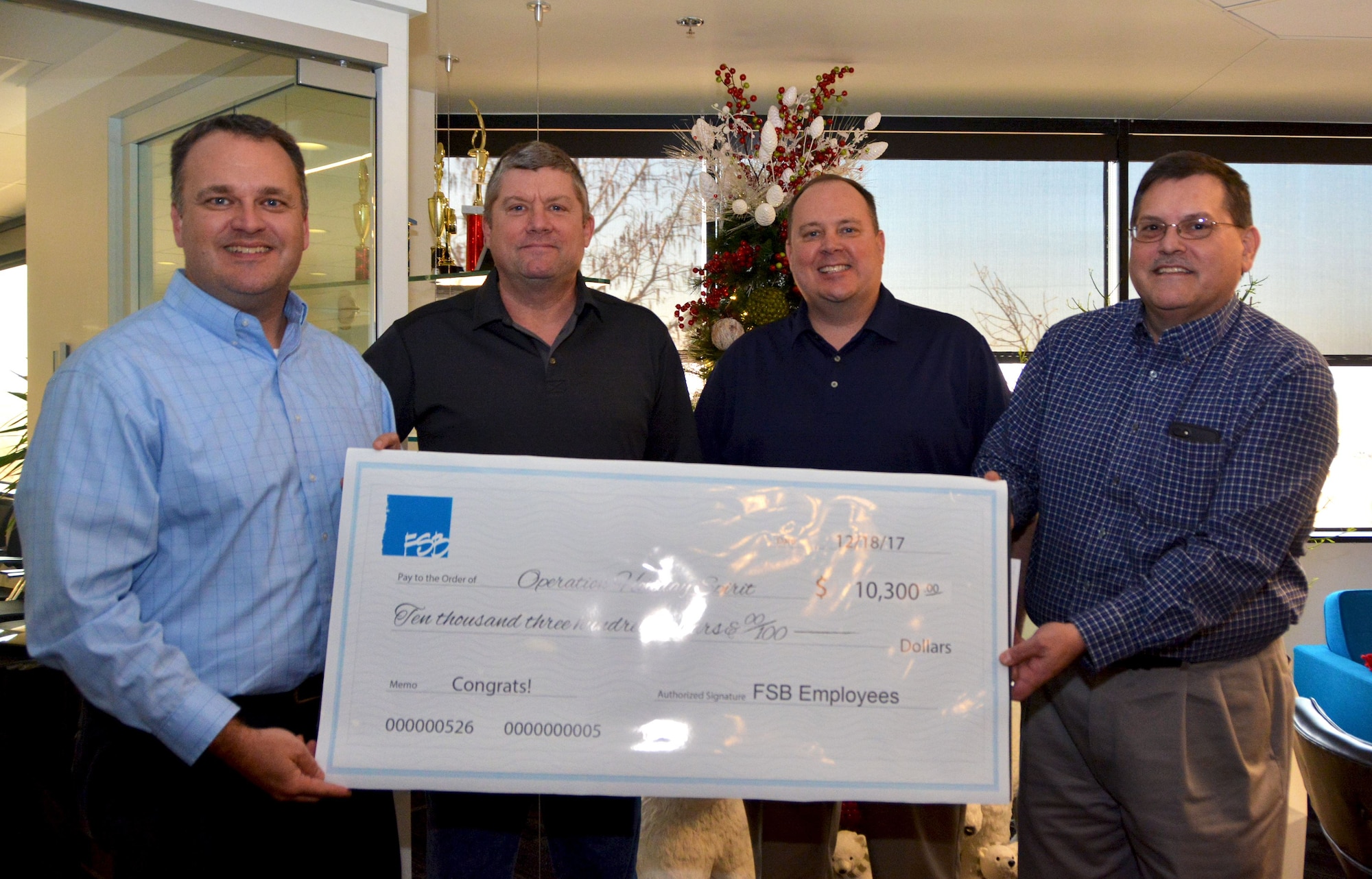 The employees of Frankfurt-Short-Bruza Architects and Engineers in Oklahoma City donated more than $10,000 Dec. 18, 2017, to Operation Holiday Spirit, a private organization that helps military families in need. Members of OHS are made up primarily of Reservists from the 513th Air Control Group and 507th Air Refueling Wing. Gene Brown, Federal Market Principal (far left), and Steve Shrum, Chief Financial Officer(far right), stand for a photo with Joe Wade, 507th Air Refueling Wing facility director (center right), and Ralph Hawkins, 513th Air Control Group executive officer (center left), after delivering the donation. The money will go towards 19 military families through OHS, which has raised more than $36,000 this year. (U.S. Air Force photo/Tech. Sgt. Samantha Mathison)