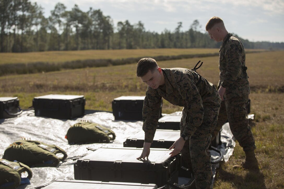 Pfc. John Campbell (left) and Pfc. Chris Kelly (right), ropers with 3rd Force Reconnaissance Company, 4th Marine Division, Marine Forces Reserve, prepare parachutes for static line and free fall jumps at Stennis Space Center in Hancock County, Mississippi, Dec. 14, 2017.