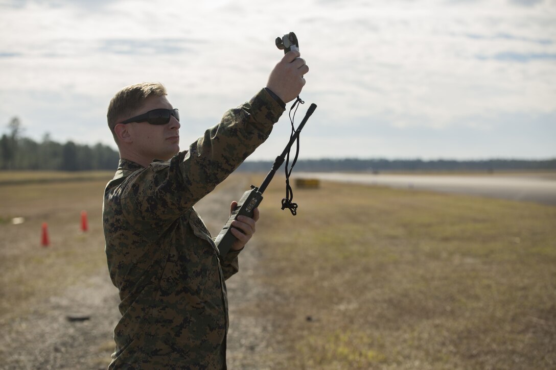 Staff Sgt. Bryan Jacobs, parachute safety officer with 3rd Force Reconnaissance Company, 4th Marine Division, Marine Forces Reserve, tests the wind speed in order to determine the high altitude release point at Stennis Space Center in Hancock County, Mississippi, Dec. 14, 2017.