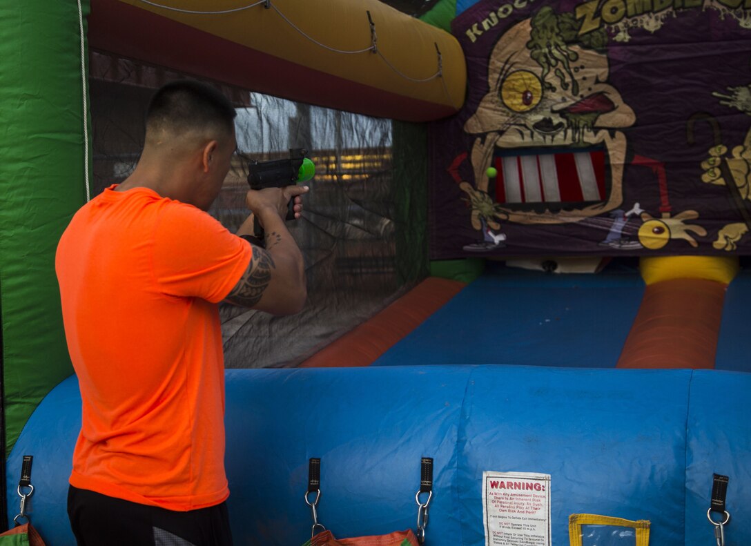 Service members, DoD employees, and family members participate in the Dead Dash Fun Run event, which included a 5K race where participants must also avoid zombies, various games, and a costume contest at the Memorial Pavilion aboard Marine Corps Air Station (MCAS) Yuma, Ariz., Oct. 31, 2017. Semper Fit hosted the annual event to help MCAS Yuma celebrate Halloween, and presented awards to the 1st, 2nd, and 3rd place male and female finishers. (U.S. Marine Corps photo taken by Lance Cpl. Isaac D. Martinez)