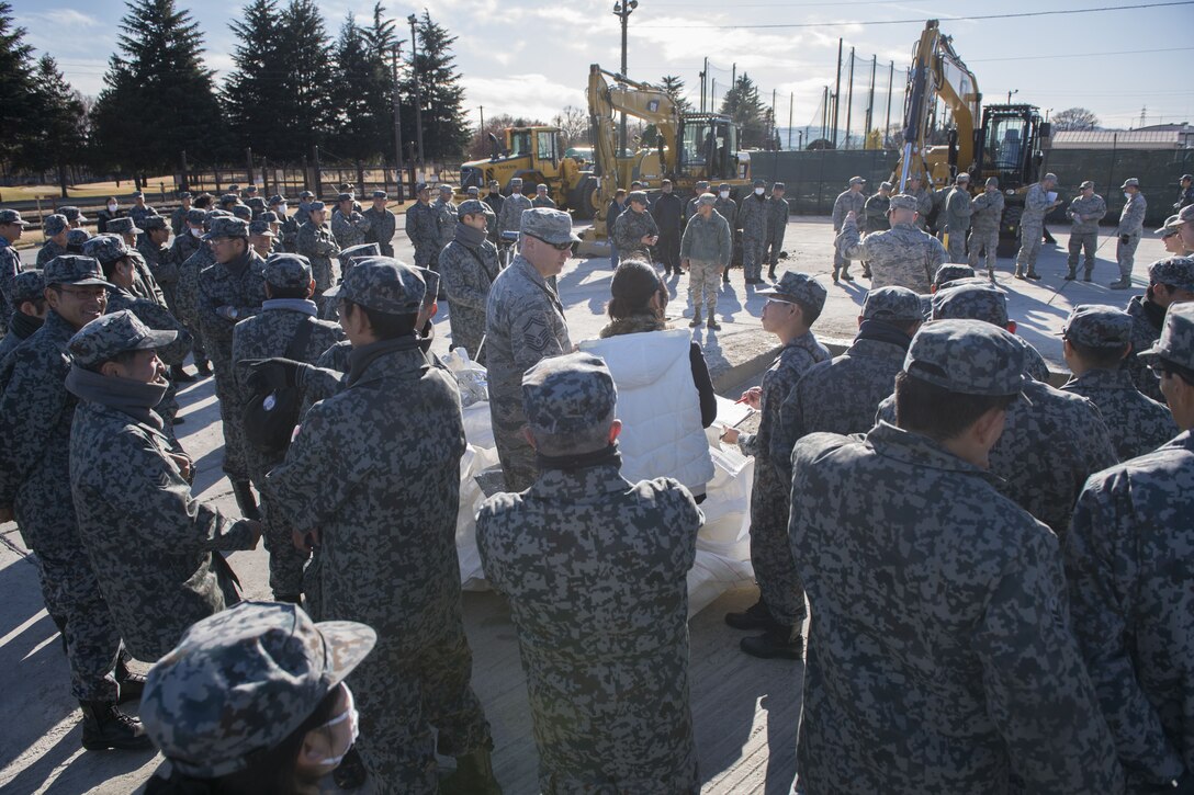 U.S. Air Force Senior Master Sgt. Alexander B. Benedict, 374th Civil Engineer Squadron heavy repair superintendent, answers Koku Jietai (Japan Air Self-Defense Force) engineers questions during a rapid airfield damage repair demonstration, Dec. 12, 2017, at Yokota Air Base, Japan.