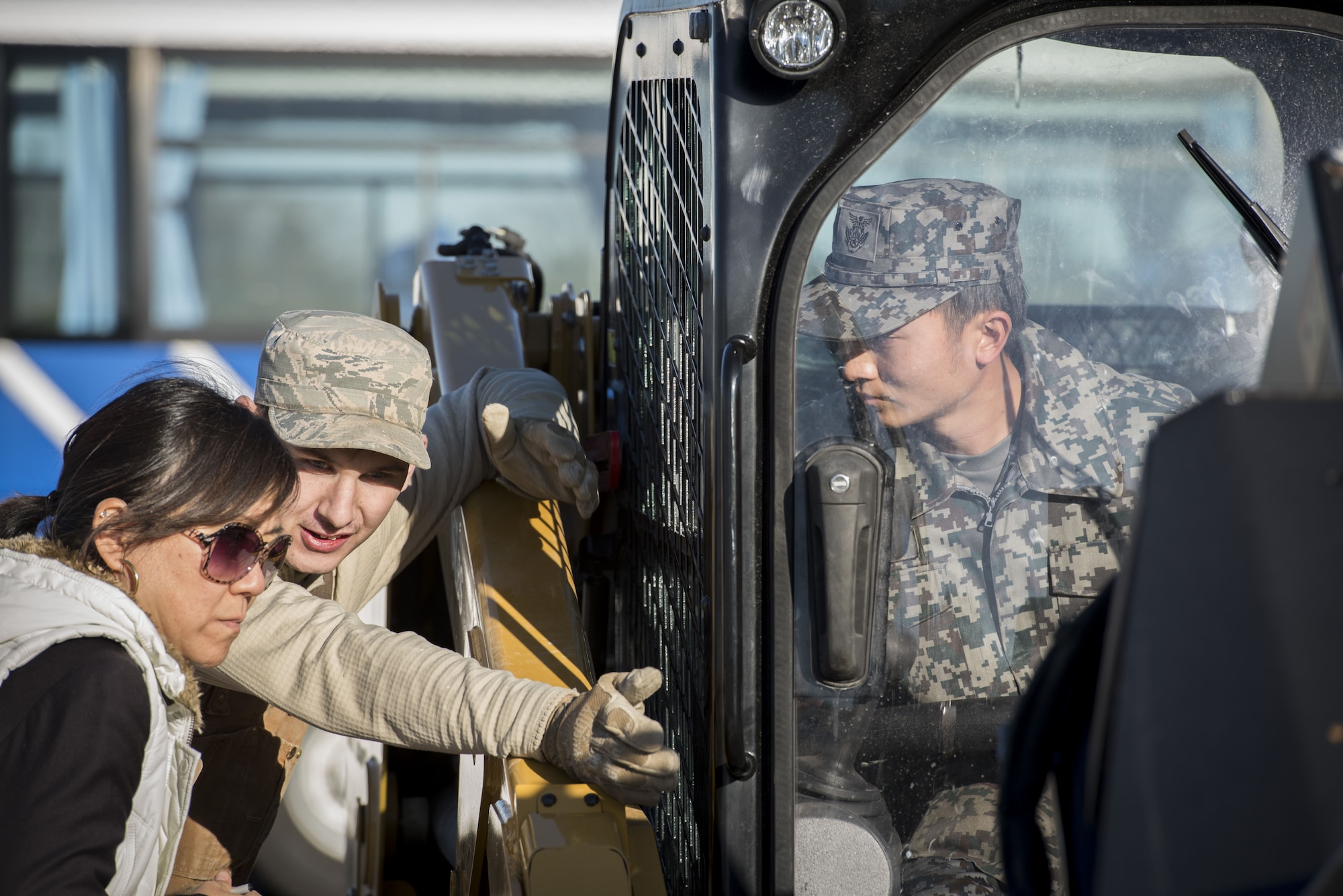 A U.S. Air Force Airman with the 374th Civil Engineer Squadron works with a translator to teach a Koku Jietai (Japan Air Self-Defense Force) engineer how to operate a piece of equipment during a rapid airfield damage repair demonstration, Dec. 12, 2017, at Yokota Air Base, Japan.