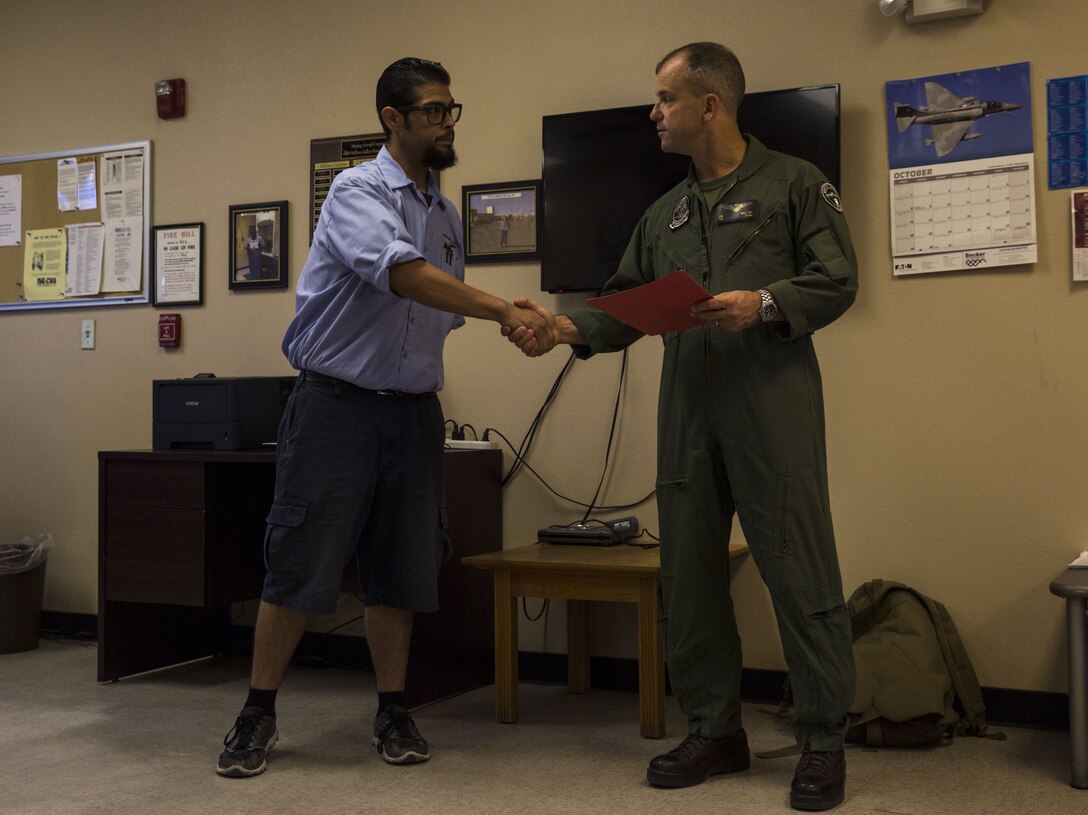 U.S. Marine Corps Col. James B. Wellons, the commanding officer of Marine Aviation Weapons and Tactics Squadron (MAWTS) One recognizes Cristobal Corona, a driver systems operator who served as a dispatcher officer for the Fuel Branch during Weapons and Tactics Instructor Course 1-18 at the Fuel Brance office on Marine Corps Air Station Yuma, Ariz., Oct. 26, 2017. The Fuel Branch supported MAWTS-1 in their efforts to provide standardized advanced tactical training during Weapons and Tactics Instructor courses twice a year in addition to daily routines and supporting other squadrons visiting or on station. (U.S. Marine Corps photo taken by Cpl. Christian Cachola)