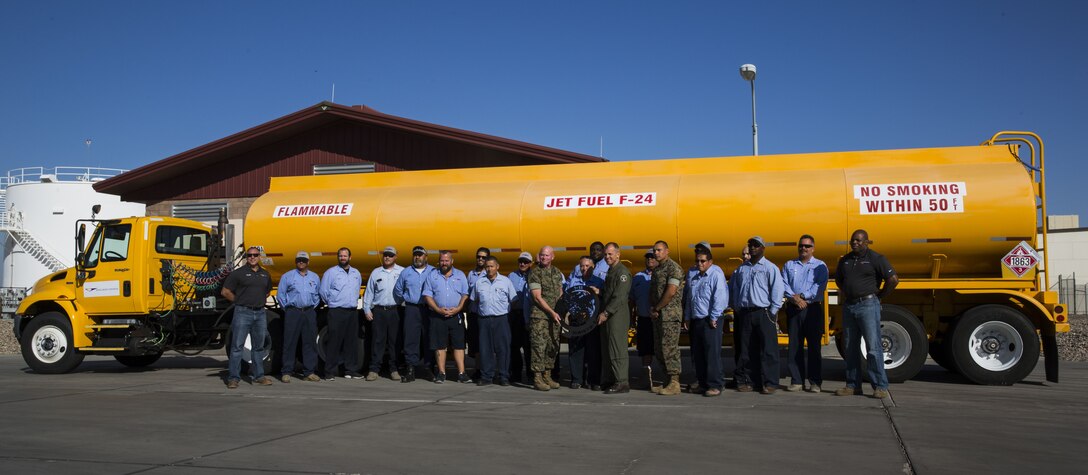 U.S. Marine Corps Col. James B. Wellons, the commanding officer of Marine Aviation Weapons and Tactics Squadron (MAWTS) One and Sgt. Maj. Thomas W. Foster, the sergeant major of MAWTS-1, takes a group photo with the Fuel Branch personnel outside of the Fuel Brance office on Marine Corps Air Station Yuma, Ariz., Oct. 26, 2017. The Fuel Branch supported MAWTS-1 in their efforts to provide standardized advanced tactical training during Weapons and Tactics Instructor courses twice a year in addition to daily routines and supporting other squadrons visiting or on station. (U.S. Marine Corps photo taken by Cpl. Christian Cachola)