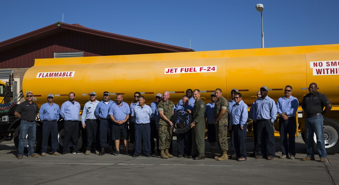 U.S. Marine Corps Col. James B. Wellons, the commanding officer of Marine Aviation Weapons and Tactics Squadron (MAWTS) One and Sgt. Maj. Thomas W. Foster, the sergeant major of MAWTS-1, takes a group photo with the Fuel Branch personnel outside of the Fuel Brance office on Marine Corps Air Station Yuma, Ariz., Oct. 26, 2017. The Fuel Branch supported MAWTS-1 in their efforts to provide standardized advanced tactical training during Weapons and Tactics Instructor courses twice a year in addition to daily routines and supporting other squadrons visiting or on station. (U.S. Marine Corps photo taken by Cpl. Christian Cachola)