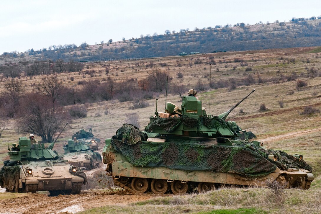 Army M2 Bradley fighting vehicles maneuver into their firing positions.