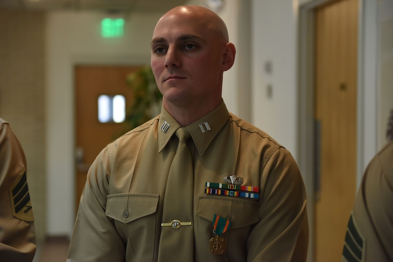 Capt. Kyle Tucker-Davis stands with his Navy-Marine Corps Achievement Medal during the award ceremony for the Training Command’s Commanding General’s Writing Competition at Marine Corps Base Quantice, Virginia, Dec. 14, 2017. Capt. Kyle Tucker-Davis, a warfighting instructor at The Basic School, took lst first place for his essay on Russian affairs, titled “New Generation Warfare: An Analysis of Russian Operations in Ukraine and Implications for the Future of U.S. Joint Operation.”