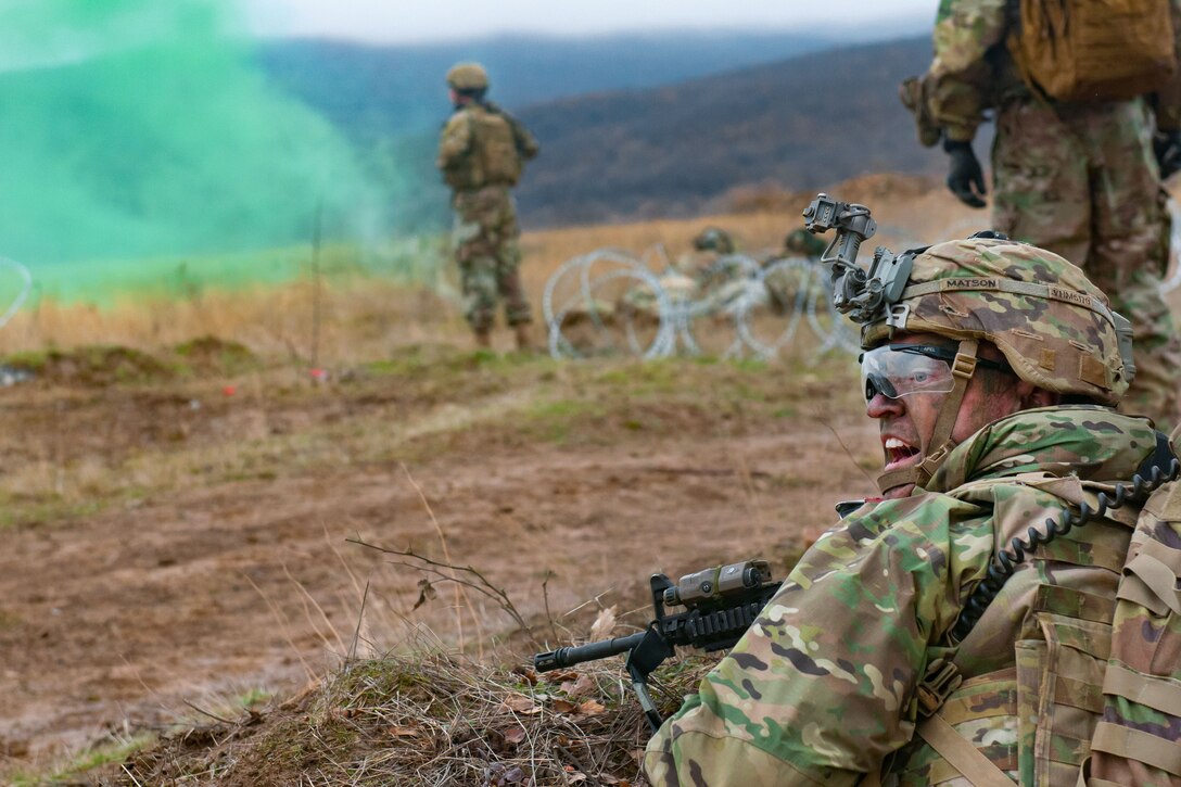 A soldier yells out follow on orders to his team members during live-fire.