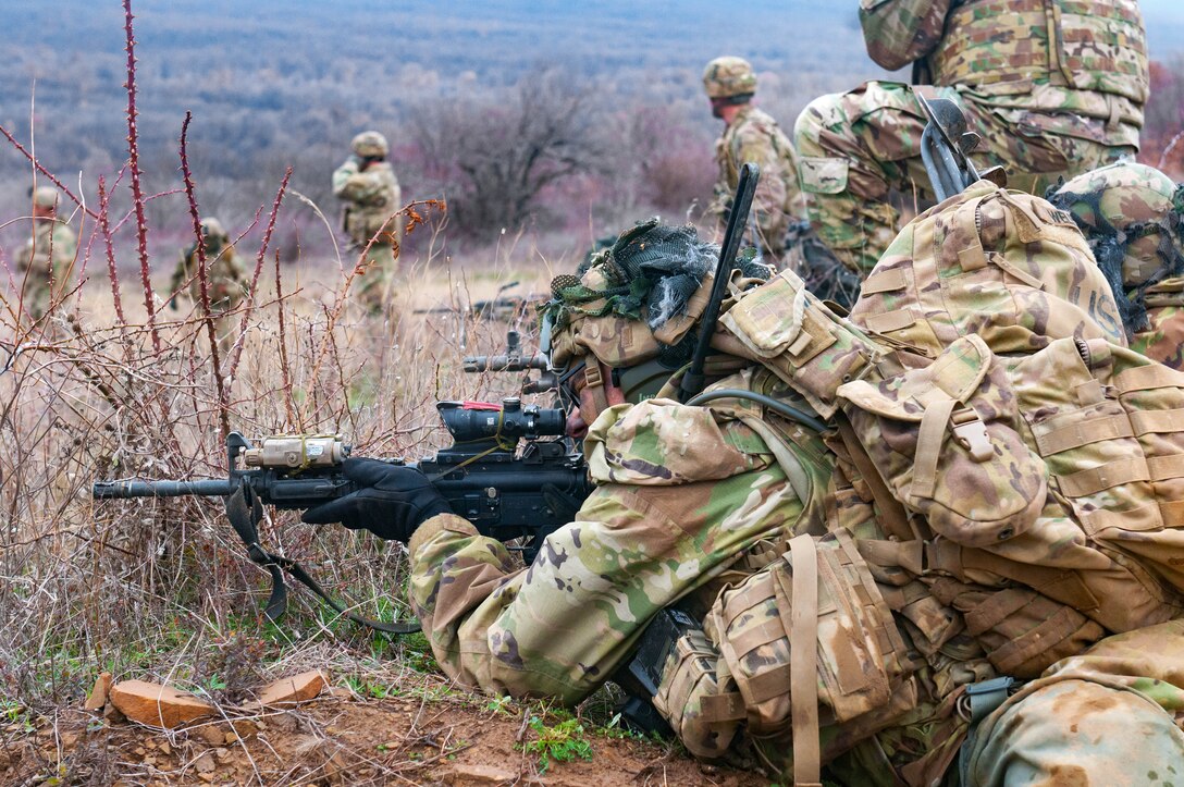 Soldiers fire their weapons while engaging targets during live-fire.