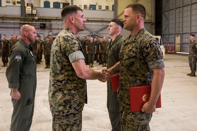 Sgt. Ethan Mintus, an unmanned aerial system operator with Marine Unmanned Aerial Vehicle Squadron 3, shakes hands with Lt. Col. Kenneth Phelps, the commanding officer of VMU-3, after receiving an award during a ceremony at Hangar 103, Marine Corps Air Station Kaneohe Bay, Dec. 11, 2017. Mintus was awarded the Navy and Marine Corps Achievement Medal with the newly authorized Remote Impact “R” Device alongside Sgt. Joseph Latsch, a fellow UAS operator with VMU-3, for their performance during combat operations.