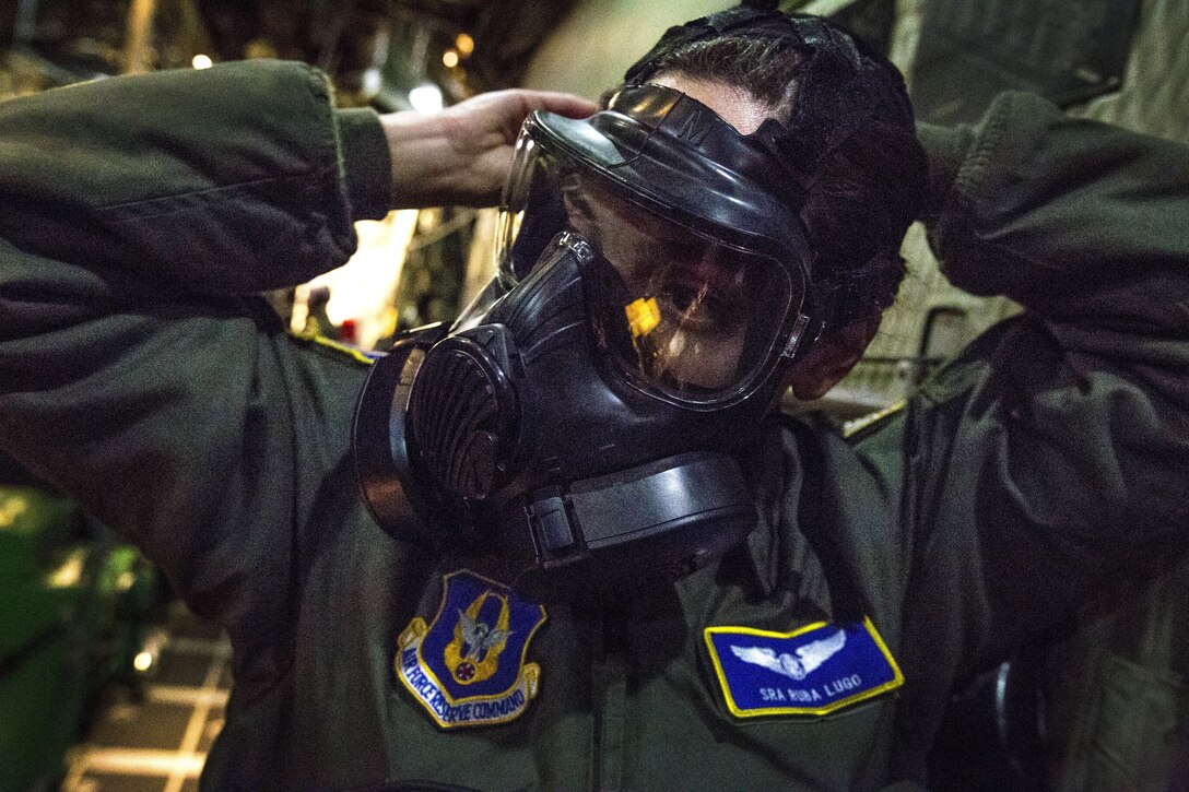 An airman checks her gas mask.