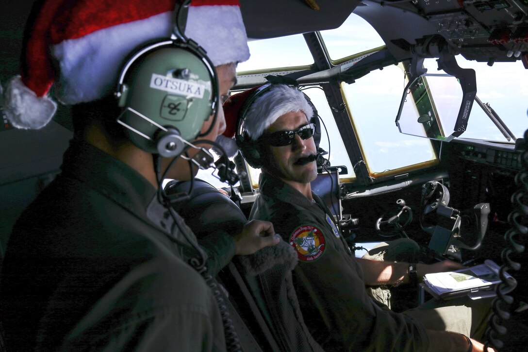 A U.S. and Japanese service member speak to each other in a cockpit of an aircraft.