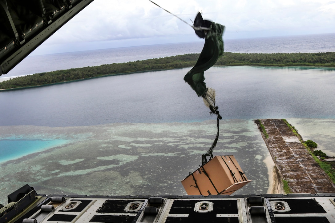 A parachute with a crate attached falls to the ground.