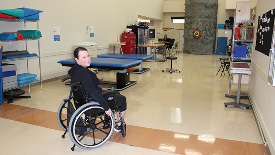 U.S. Air Force Maj. Stephanie Proellochs relies on her wheelchair as she heads in to her daily physical therapy session at Walter Reed Medical Center, Nov. 8, 2017. Proellochs received a below-the-knee amputation in September 2017 to treat a malignant tumor that had metastasized and spread. (U.S. Air Force photo by Karina Luis)