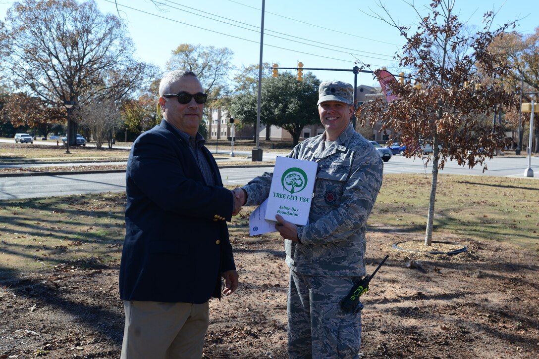 U.S. Air Force Lt. Col. Robert Grover, 20th Civil Engineer Squadron (CES) commander, accepts the Tree City USA award from Everett Sharpe, South Carolina Forestry Commission urban forester, at Shaw Air Force Base, S.C., Dec. 13, 2017.