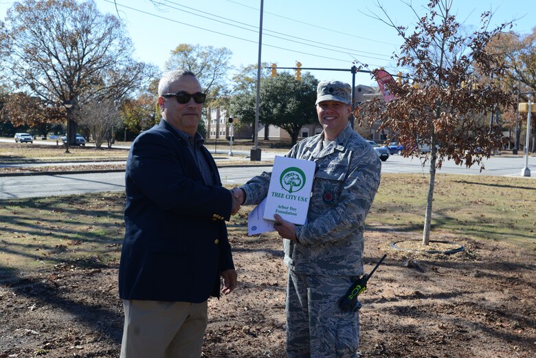 U.S. Air Force Lt. Col. Robert Grover, 20th Civil Engineer Squadron (CES) commander, accepts the Tree City USA award from Everett Sharpe, South Carolina Forestry Commission urban forester, at Shaw Air Force Base, S.C., Dec. 13, 2017.