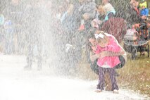 Frosty Fest attendees play in the snow as it falls to the ground at Shaw Air Force Base, S.C., Dec. 17, 2017.