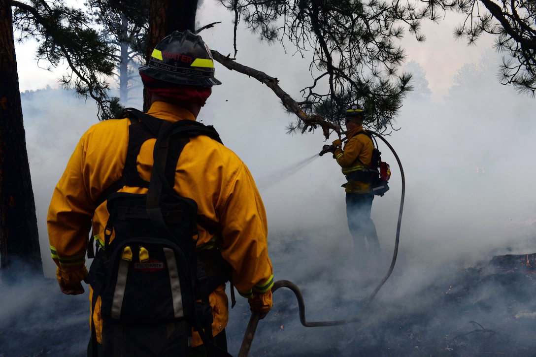 Airmen and firefighters work together to put out fire