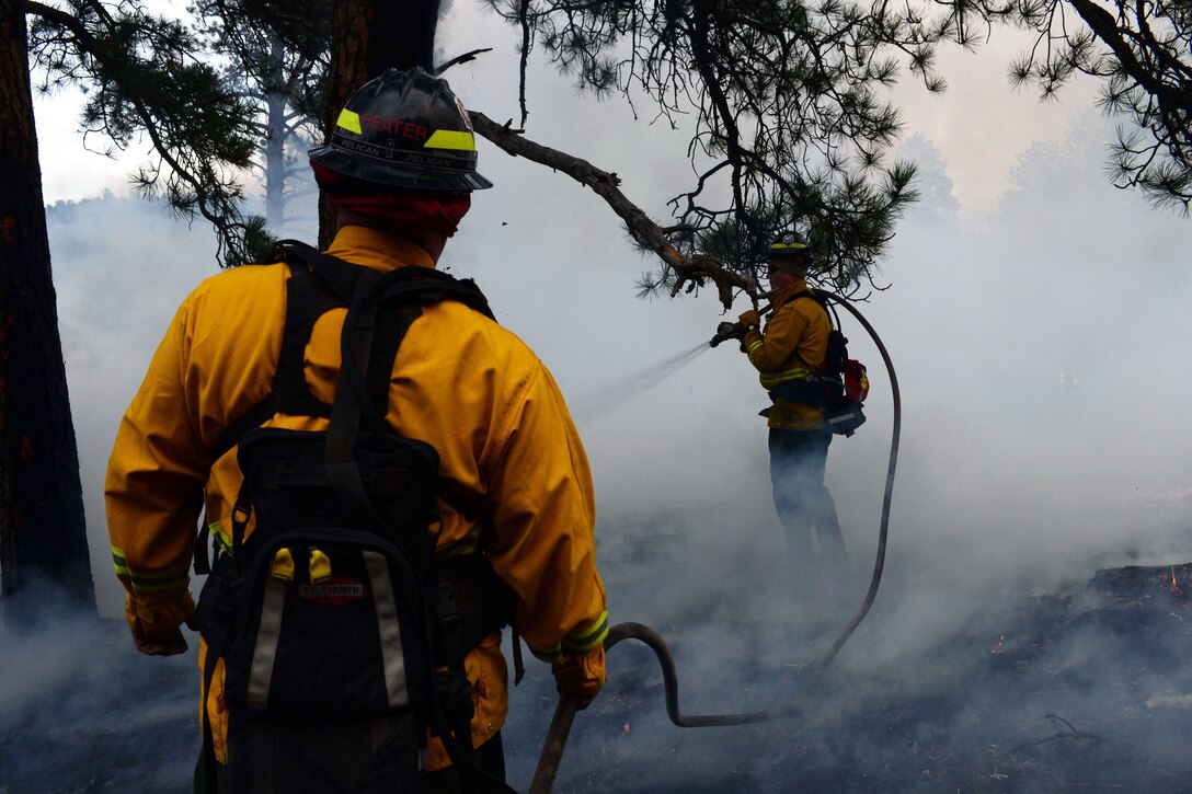 Airmen and firefighters work together to put out fire