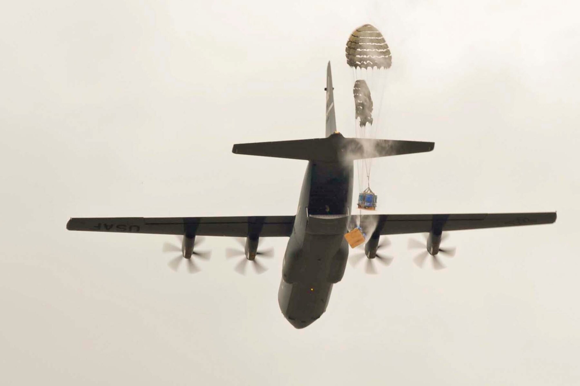 Parachutes deploy after pallets are dropped from a C-130J during Operation Tenacious Turtle Nov. 21, 2017, at an airfield in Hope, Arkansas.