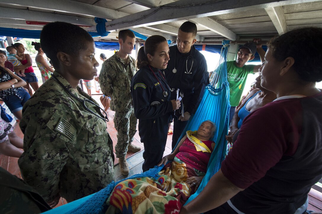 Doctors diagnose an elderly woman on her houseboat near a remote village along the Amazon River.