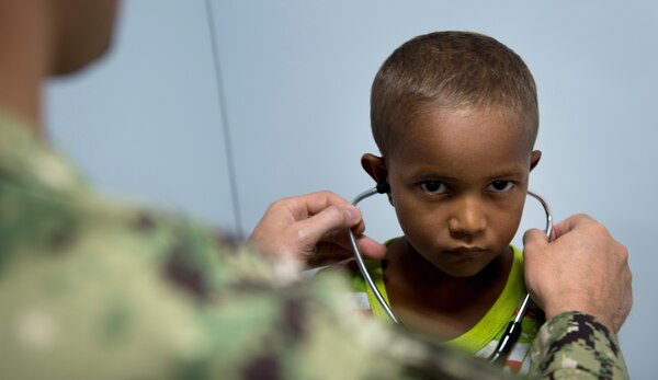 Doctor puts a stethoscope on a Brazilian boy.