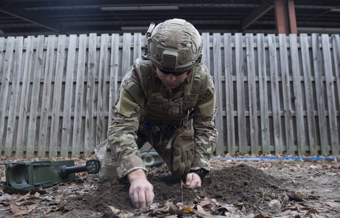 Senior Airman Matthew Koser, Civil Engineer Squadron Explosive Ordnance Disposal technician digs for a mine during the EOD Olympics Dec.15, 2017.