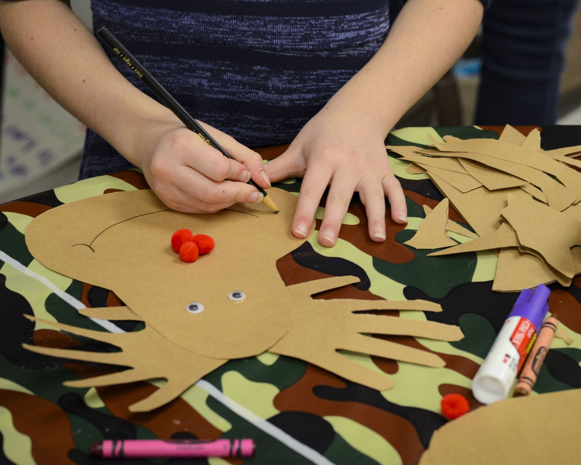 A child makes a craft during a holiday party, Dec. 15, 2017, at Moody Air Force Base, Ga. The Airman and Family Readiness Center hosted the event for families of deployed or remote-tour Airmen, and families enrolled in the Exceptional Family Member Program. During the party, families enjoyed a turkey dinner, played games, made arts and crafts for their loved ones and shared a special moment with Santa Claus. (U.S. Air Force photo by Senior Airman Lauren M. Sprunk)